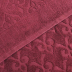 Relax Home Linens Andalus burgundy Egyptian cotton towel set with an intricate embossed damask pattern.